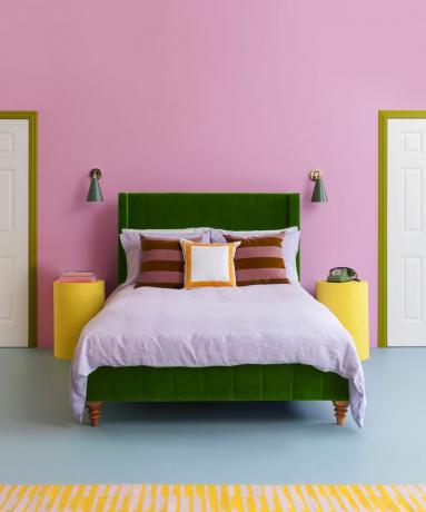 спальня с розовыми стенами, зеленым изголовьем и сиреневым постельным бельем