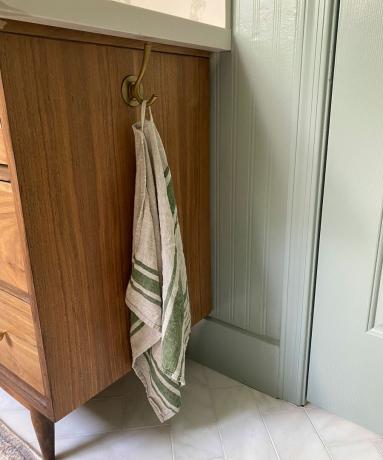 Meuble de salle de bain en bois avec crochet à serviette en laiton installé