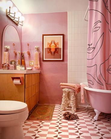 ვარდისფერი თანამედროვე აბაზანა თეთრი შაბლონით იატაკისა და ჭერის ფილებით და მხატვრული საშხაპე ფარდით