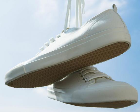 sepatu tenis plimsolls putih digantung - GettyImages-122667282