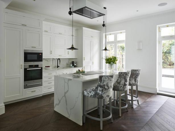 hvitt kjøkken med marmor benkeplater kjøkkenøya
