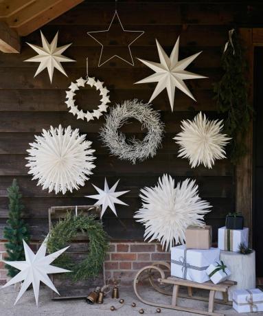 Божићни украси на отвореном са приказом великих папирних снежних пахуља и звезда