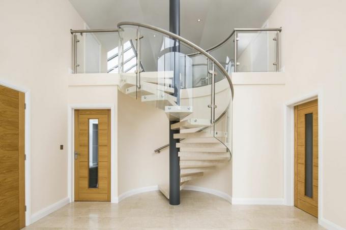 Mramorové točité schodiště od společnosti Spiral UK ve vstupní hale s dvojitou výškou