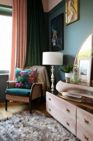 Grünes Schlafzimmer mit rosa Sessel