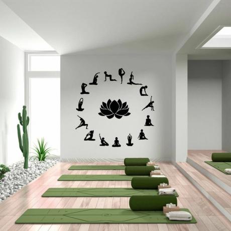 witte yogaruimte met muursticker en groene yogamatten
