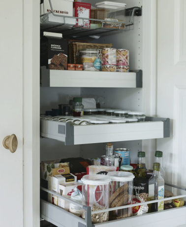 Výsuvné zásuvky v bílé kuchyňské skříni s potravinami uloženými v IKEA