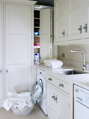 Design del ripostiglio in stile contemporaneo con unità in stile shaker color crema, cesto della biancheria in vimini e lavatrice e asciugatrice