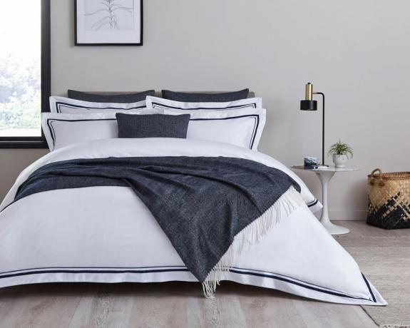 biancheria da letto bianca con copriletto grigio