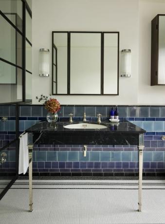värillinen kaakeloitu kylpyhuone, jossa on mustat kalusteet ja tyylikäs suihkuseinä