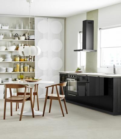Een zwart-witte Ikea-keuken met planken en een eettafel met stoelen