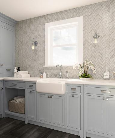 Esquema de lavanderia de neutros frescos com armários cinza claro, backsplash de azulejos cinza e grande pia de cerâmica
