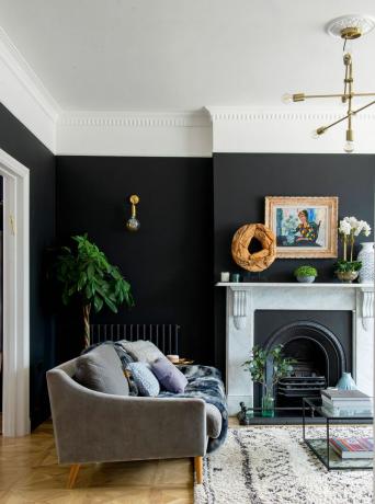 Dzīvojamās istabas ideja ar melnu sienu un koka grīdu