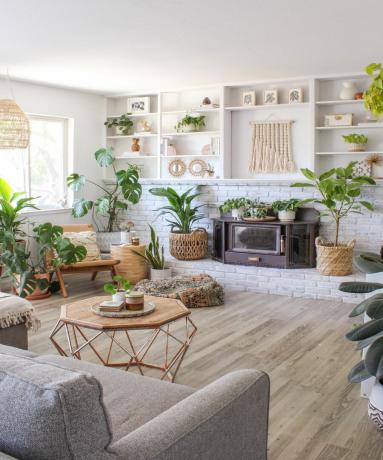 צמחי בית בסלון עם אח ברזל אח, מתלי קיר ודגשים מעץ טבעי כולל סלסלות נצרים
