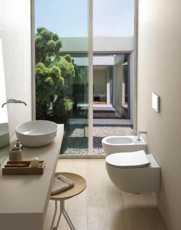 salle de bain de couleur claire avec de grandes fenêtres et un schéma neutre