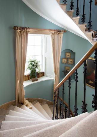 Zilas kāpnes ar aizkariem un logiem, mākslas darbi