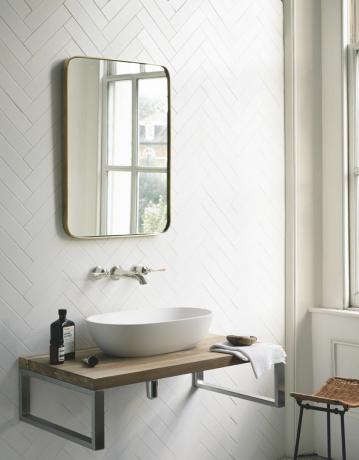μπάνιο με λευκά πλακάκια ψαροκόκαλο με στρογγυλεμένο γωνιακό καθρέφτη και ανεξάρτητο νεροχύτη