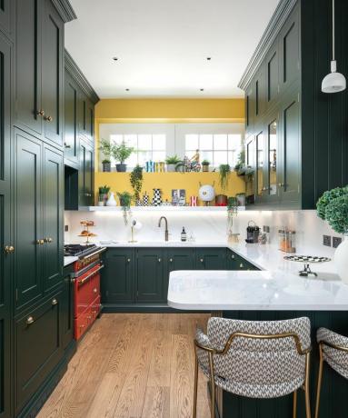 Piccola cucina verde scuro zona pranzo con mobili incorporati su misura