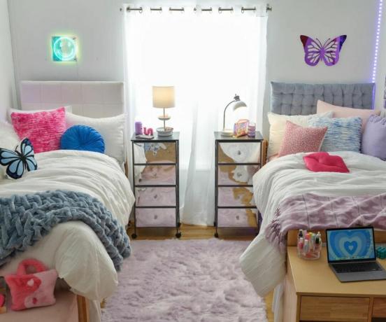 y2k stiliaus bendrabučio kambarys su dviem lovomis ir spalvingais akcentais