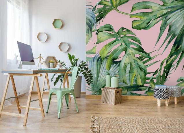 vaaleanpunainen ja trooppinen seinä toimistossa yksinkertaisemmilla, skandi -tyylisillä huonekaluilla