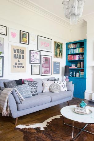 Stue med grå sofa, gallerivegg og innebygd kommode