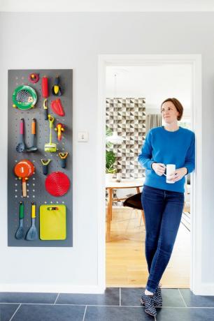 जेसिका प्रेस्टन अपनी रसोई के दरवाजे पर बर्तनों को स्टोर करने के लिए इस्तेमाल किए जाने वाले पेगबोर्ड के बगल में खड़ी है