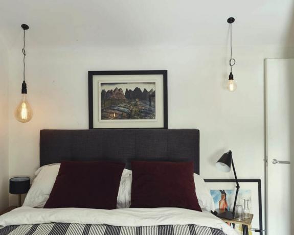 ベッドサイドに不一致の裸電球ペンダント照明を備えた小さな寝室 - フィリップ・ローターバック写真家