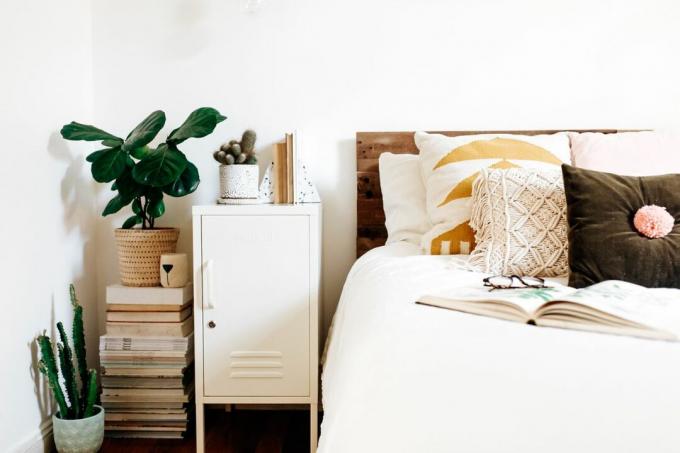 Ganz weißes Schlafzimmer mit Zimmerpflanzen und Kissen im Boho-Stil