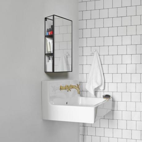 Decoração de banheiro branca com pia suspensa e armário de banheiro industrial espelhado