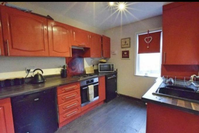 Industrijsko siva kuhinja Steva in Katelin Haworth je bila dvignjena z rdečkasto rdečo barvo