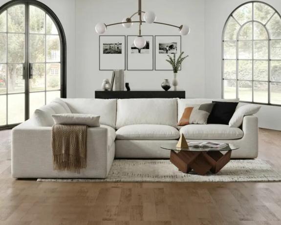 Törtfehér L alakú szekcionált kanapé egy modern nappaliban