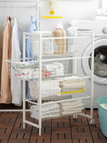 eine Waschmaschine mit fahrbarem Drahtkorb von IKEA in einer Waschküche