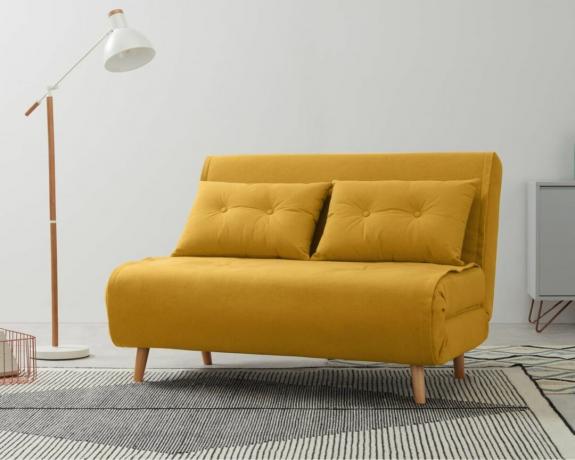 Keltainen kangasvuodesohva modernissa olohuoneessa