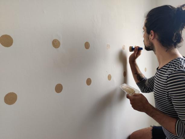 Criação de uma parede de bolinhas DIY com esponja e tinta dourada