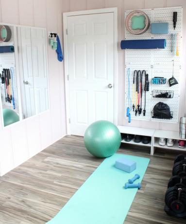 małe studio jogi i domowa siłownia DIY z niebieską matą do jogi, ciężarkami i piłką do ćwiczeń - Lela Burris