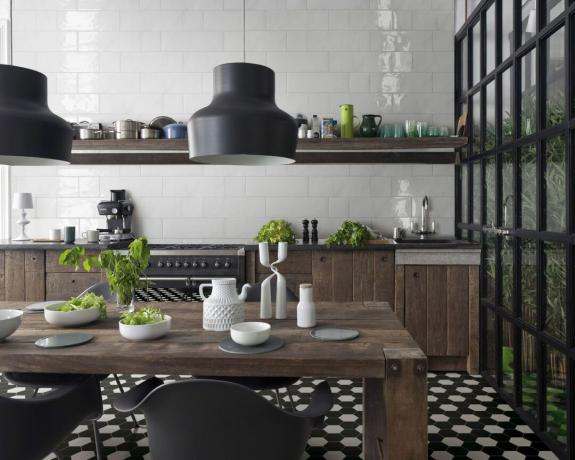 črno -bele enobarvne viktorijanske neglazirane šesterokotne ploščice v kuhinji v industrijskem slogu z okrašeno leseno omarico in okni iz črnega kovinskega okvirja ter sodobno razsvetljavo iz sredine stoletja
