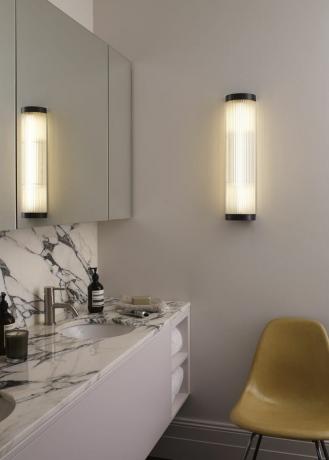 marmorierter Waschbeckenbereich mit Waschbecken und großem Spiegel und Licht