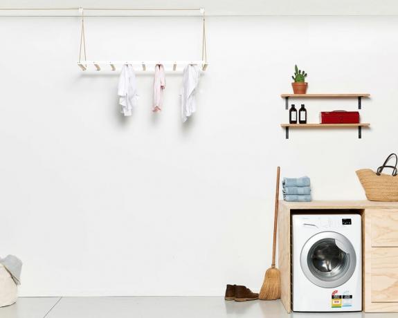 hangend droogrek in een wasruimte met wasmachine van George en Willy