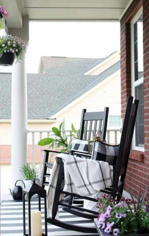 Elegant verandaopplegg med svarte gyngestoler, monorutete puter og monostripeteppe.