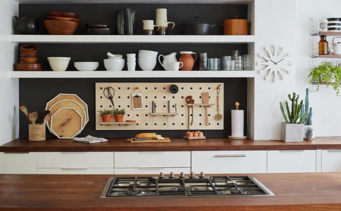 Cocina de galera con alacenas blancas y superficies de madera de Wearth London