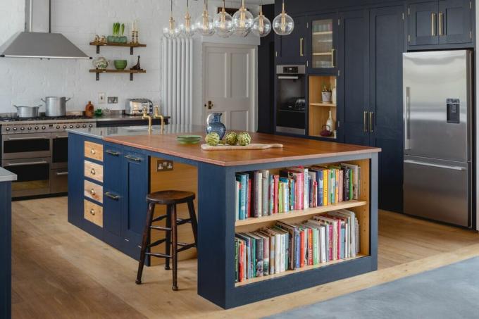 Modrá kuchyně s ostrůvkem a úložištěm knih