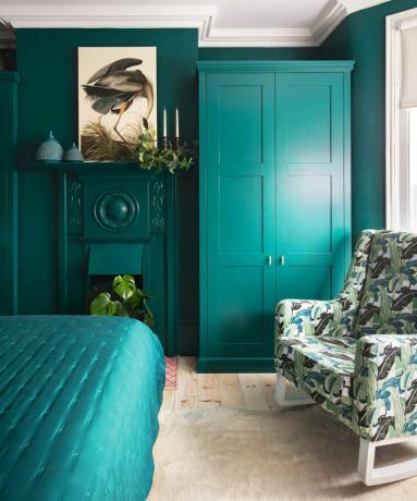 ห้องนอนสีฟ้าอมเขียวพร้อมตู้เสื้อผ้าหลักที่เข้าชุดกันและเก้าอี้พิมพ์ลายฝ่ามือ