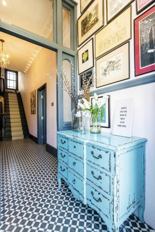 パターン化されたモノクロの床タイルと青い箪笥のある廊下