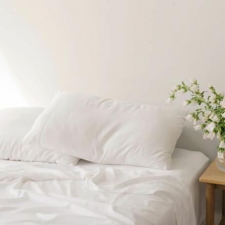 Jaukus žemės bambuko paklodės baltos spalvos rinkinys ant lovos su baltomis gėlėmis ant lovos