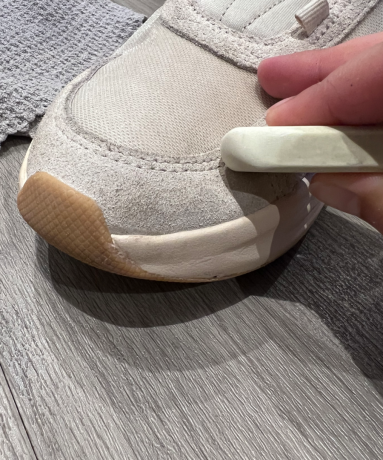 Una gomma da cancellare bianca su scarpe da ginnastica neutre