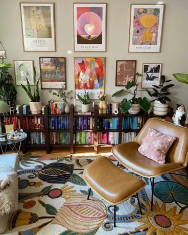 Una sala de estar con una estantería colorida y arte mural.