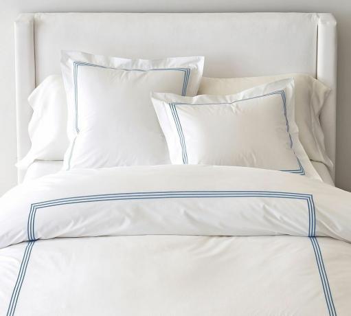 Roupa de cama branca com detalhes em azul