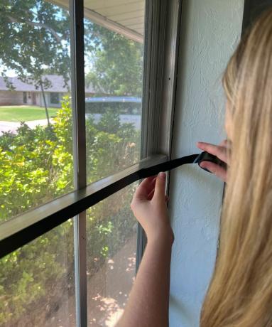 Asegure con cuidado la cinta aislante negra al marco de la ventana
