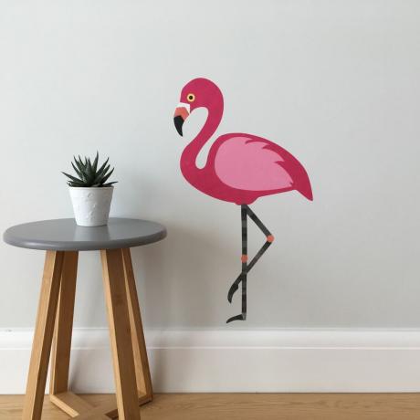bijela shema soba s velikom ružičastom zidnom naljepnicom flamingo i malim bočnim stolićem s sobnom biljkom od kameleonske zidne umjetnosti
