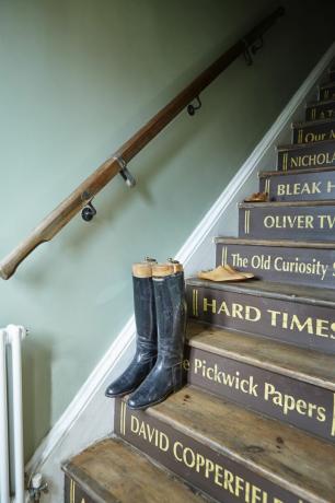 jahalni škornji na stopnišču z naslovi knjig