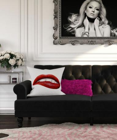 melns dīvāns un grafiskie spilveni ar Paris hilton apdruku